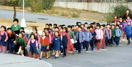 ◇ 선생님(사진 맨 오른쪽)의 안내를 받으면서 학교로 들어가고 있는 소학교 어린이들. 북한에선 4월 1일 새 학년이 시작된다