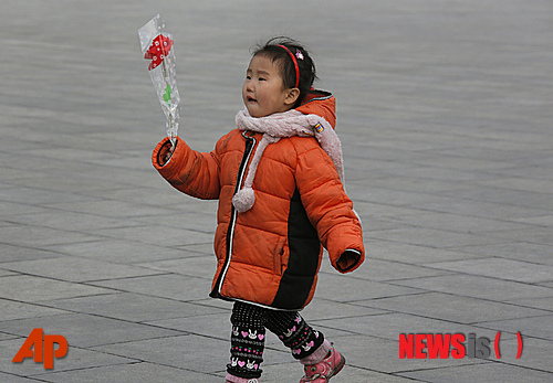'광명성절‘로 불리는 故 김정일 국방위원장 생일인 16일 북한 평양에서 한 소녀가 꽃을 들고 김일성-김정일 동상 앞으로 걸어가고 있다.