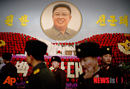 ‘광명성절‘로 불리는 故 김정일 국방위원장 생일인 16일 북한 평양에서 군인들이 꽃으로 장식된 故 김 위원장의 초상화 앞을 지나고 있다.