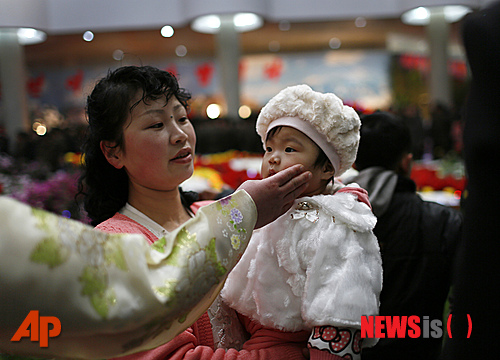 '광명성절‘로 불리는 故 김정일 국방위원장 생일인 16일 북한 평양 꽃전시장을 찾은 가족과 아이가 곱게 옷을 차려입고 있다.