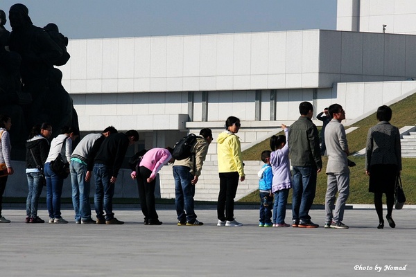 외국관광객도 김일성과 김정일의 동상에 허리 굽혀 절 해야한다. 이것은  중국 관광객들이 동상을 향해 허리를 숙이는 장면이다.