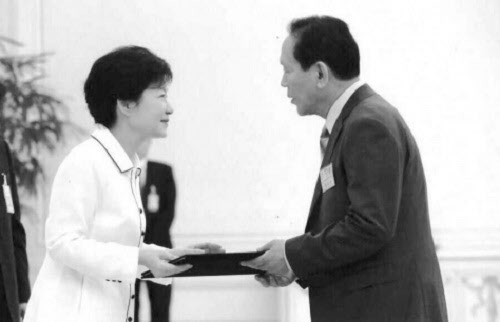 홍순경씨(오른쪽)가 작년 7월 대통령직속 국민대통합위 위원으로 위촉돼 박근혜 대통령으로부터 임명장을 수여받고 있다. /책 '만사일생' 중