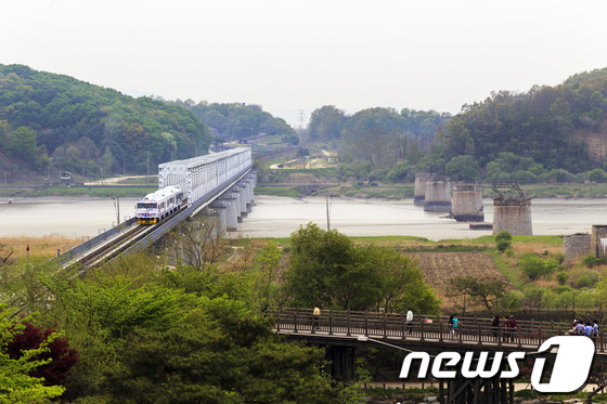 DMZ 열차가 임진강 철교를 지나고 있다. 그 옆으로 한국전쟁으로 무너진 철교가 보인다. © News1