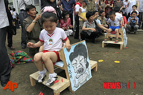 '국제아동절'인 1일 북한 평양 한 보육원에서 한 아이가 박근혜 대통령을 풍자한 그림을 잡고 있다.