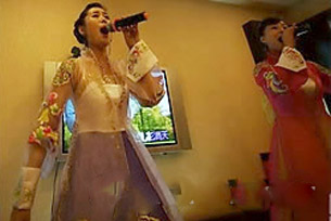 중국 베이징 소재 북한식당에서 여성 접대원(종업원)들이 속살이 비치는 대담한 한복 차림으로 노래를 부르고 있다. /조선일보 D.B