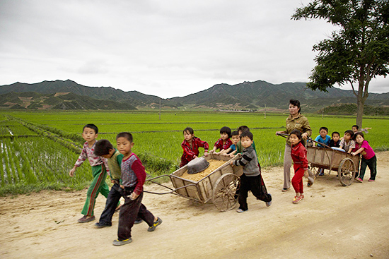 사진은 지난 6월 20일 함경북도의 한 비포장도로에서 어린이들이 파인 길을 메우기 위해 리어카에 흙을 실어 나르고 있는 모습./AP 뉴시스