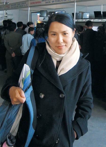 재미(在美) 소설가 수키 김씨가 중국 단둥(丹東)에서 한쪽 어깨에 가방을 메고 서있다. 2011년 7월부터 12월까지 평양 과학기술대에서 영어를 가르친 그는 “북한이 세상에서 가장 끔찍한 곳”이라고 했다. /수키 김 홈페이지
