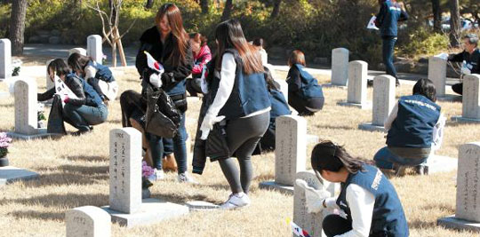 탈북 대학생들이 14일 오전 국립서울현충원을 찾아 6·25와 월남전 전사자 묘역을 단장하는 봉사 활동을 하고 있다. /민주평통 제공