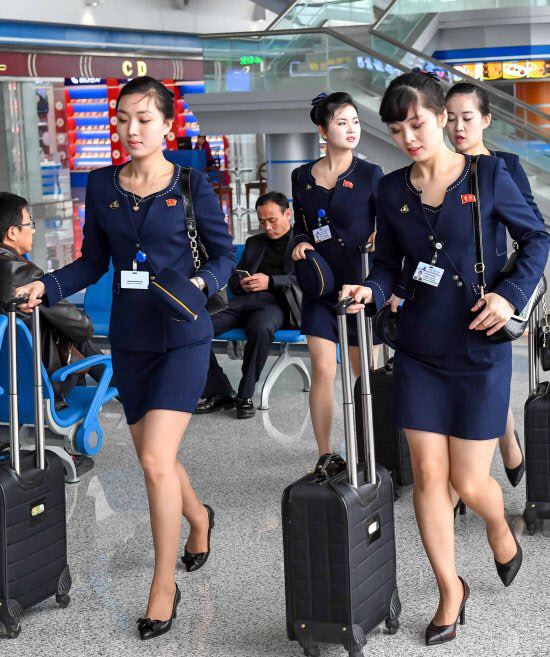 고려항공 여자 승무원들이 8일 평양순안국제공항에서 중국 심양으로 나가는 비행기에 탑승하고 있다. /뉴시스