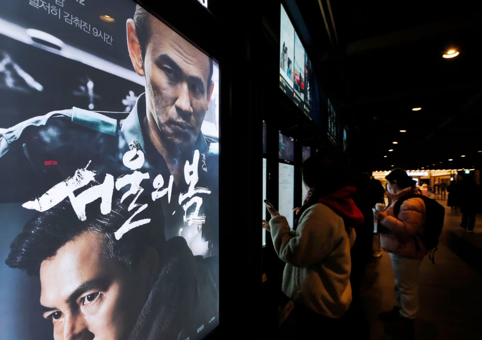 서울의 한 영화관을 찾은 한 시민이 12·12 군사쿠데타를 다룬 영화 ‘서울의 봄’ 포스터 앞을 지나가고 있다. /뉴스1