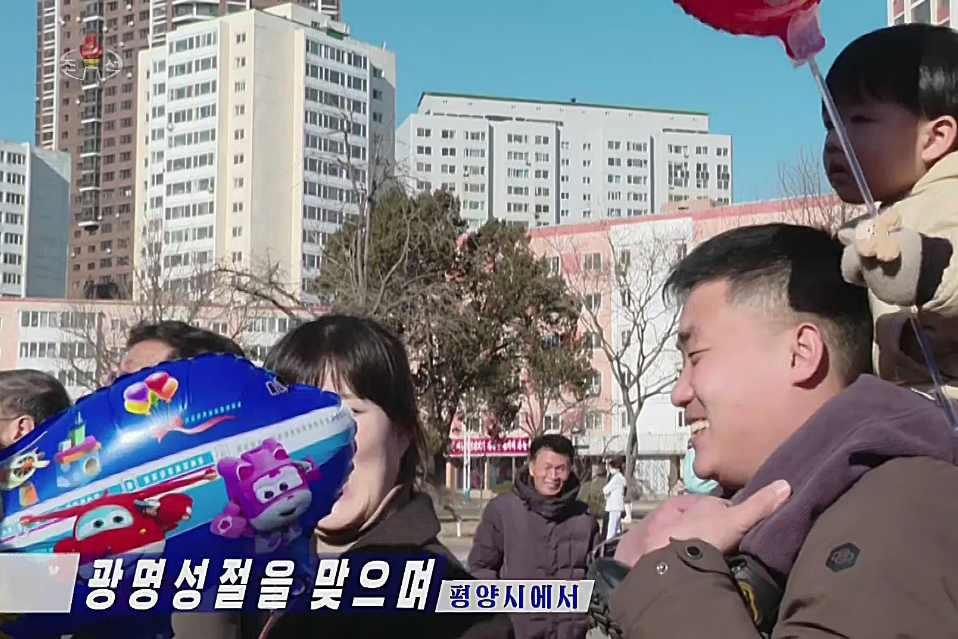 북한 조선중앙TV가 지난 16일 평양시 공연 소식을 전하던 화면. 아이를 대동한 한 관객이 든 풍선에 한국 애니메이션 캐릭터가 그려져 있다. /조선중앙TV 연합뉴스